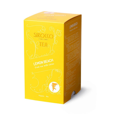 Eine leuchtend gelbe Kartonverpackung für Sirocco „Lemon Beach“ Bio-Früchtetee mit Zitrone, verziert mit weißen Ornamenten und einer Seitenwand mit der mehrsprachigen Zutatenliste.