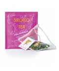 Ein leuchtend pinkfarbenes Tee-Sachet für Sirocco „Piña Moringa“ Früchte- und Kräutertee, daneben ein transparenter Pyramidenteebeutel mit grünen Moringa-Blättern und gelben Fruchtstücken.