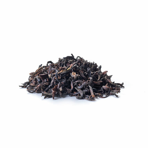 Ein kleiner Haufen loser Sirocco „Purple Breeze“ Darjeeling-Tee auf weißem Hintergrund, bestehend aus dunklen, gekräuselten und leicht gedrehten hochwertigen Schwarzteeblättern.