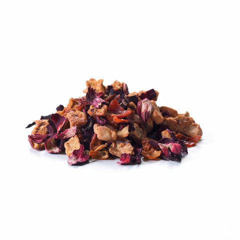 Ein kleiner Haufen loser Sirocco „Red Kiss“ Früchtetee auf weißem Hintergrund, bestehend aus großen, leuchtend roten Hibiskusblüten vermischt mit groben Stücken von getrocknetem Apfel und Hagebutte.