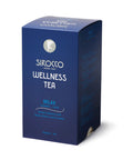 Eine dunkelblaue Kartonverpackung für Sirocco „Wellness Tea Relax“ Bio-Kräutertee mit silberweißer Aufschrift und einer Seitenwand, die eine mehrsprachige Zutatenliste mit Lindenblüten und Lavendel zeigt.