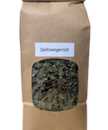Eine aufrechte, braune Papiertüte mit einem Sichtfenster, das getrocknete, grob geschnittene Blätter von Spitzwegerich zeigt. Ein weißes Etikett trägt die Aufschrift "Spitzwegerich".