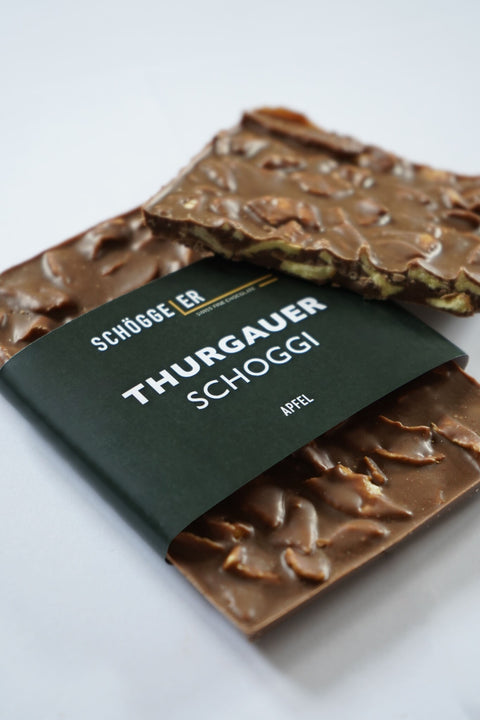 Schoggistängel mit Nüssen und einer dunkelgrünen Banderole mit der Aufschrift „Thurgauer Schoggi“.