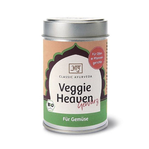 Eine silberne Gewürzdose für „Classic Ayurveda Veggie Heaven Gewürz“ mit einem grün-pfirsichfarbenen Etikett, dekorativem Bogen, Bio-Logo und dem Untertitel „Für Gemüse“.